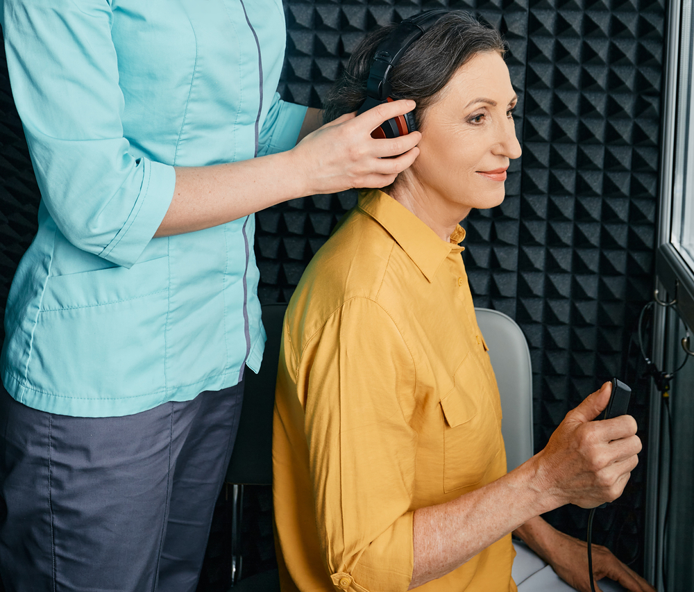 mature woman in hearing test booth