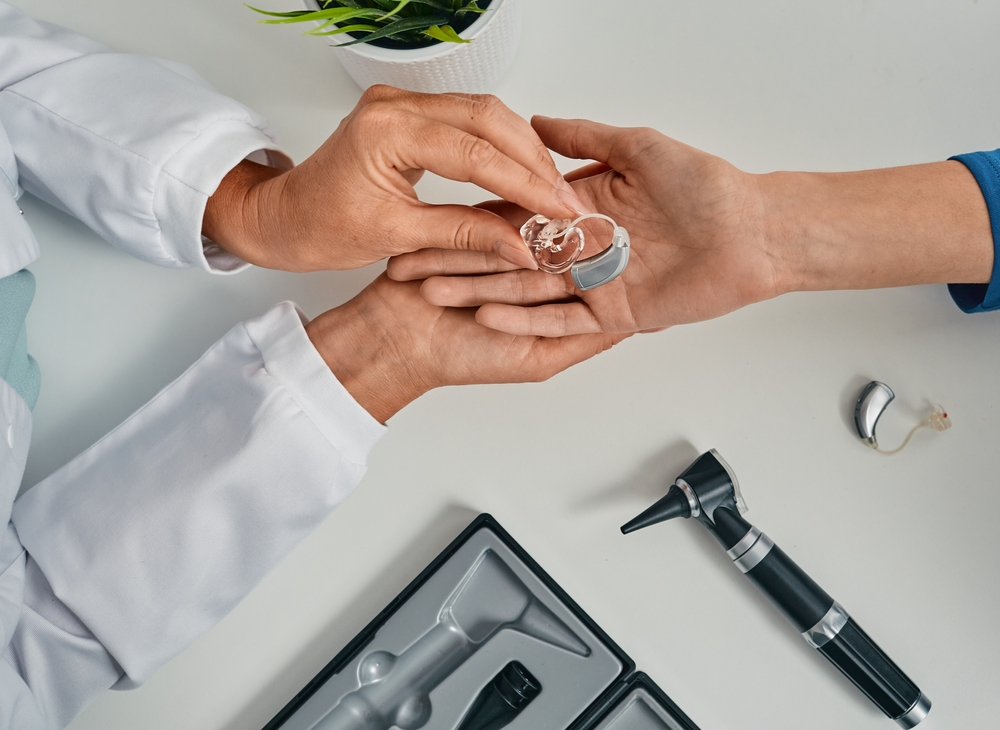 Audiologist puts modern BTE hearing aid in patient hand