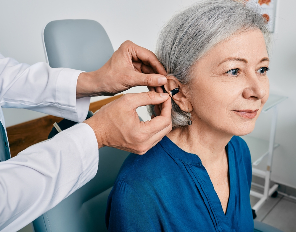 senior woman getting a hearing aid