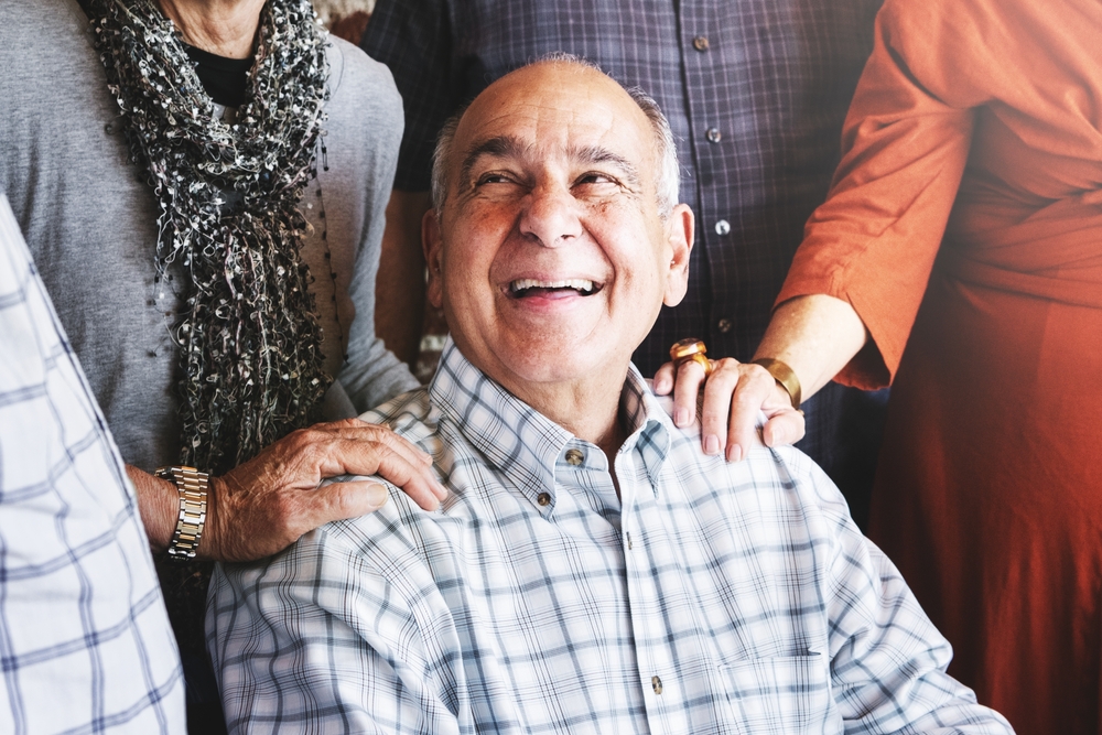elderly man smiling and surrounded by a group of senior adults